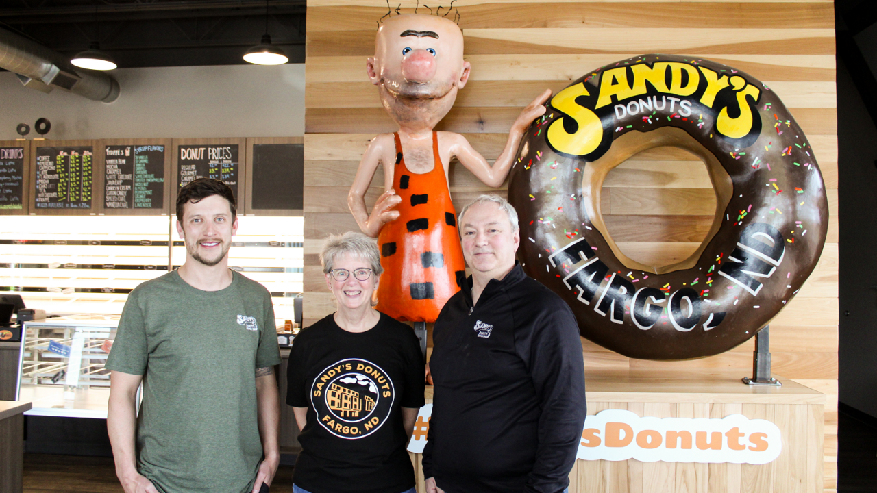 Photo of Sandy’s Donuts’ Jeff Ostlund, Joan Wilson and Kent Flagtwet