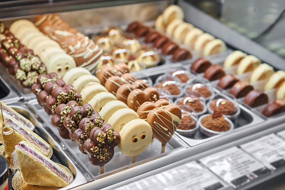 Photo of chocolate lollipops and muffins in bakery shop display