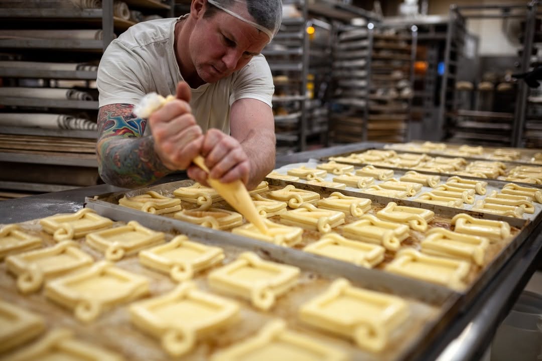 A baker at Melbourne Cybake user Dench Bakers prepares trays of Danish pastries