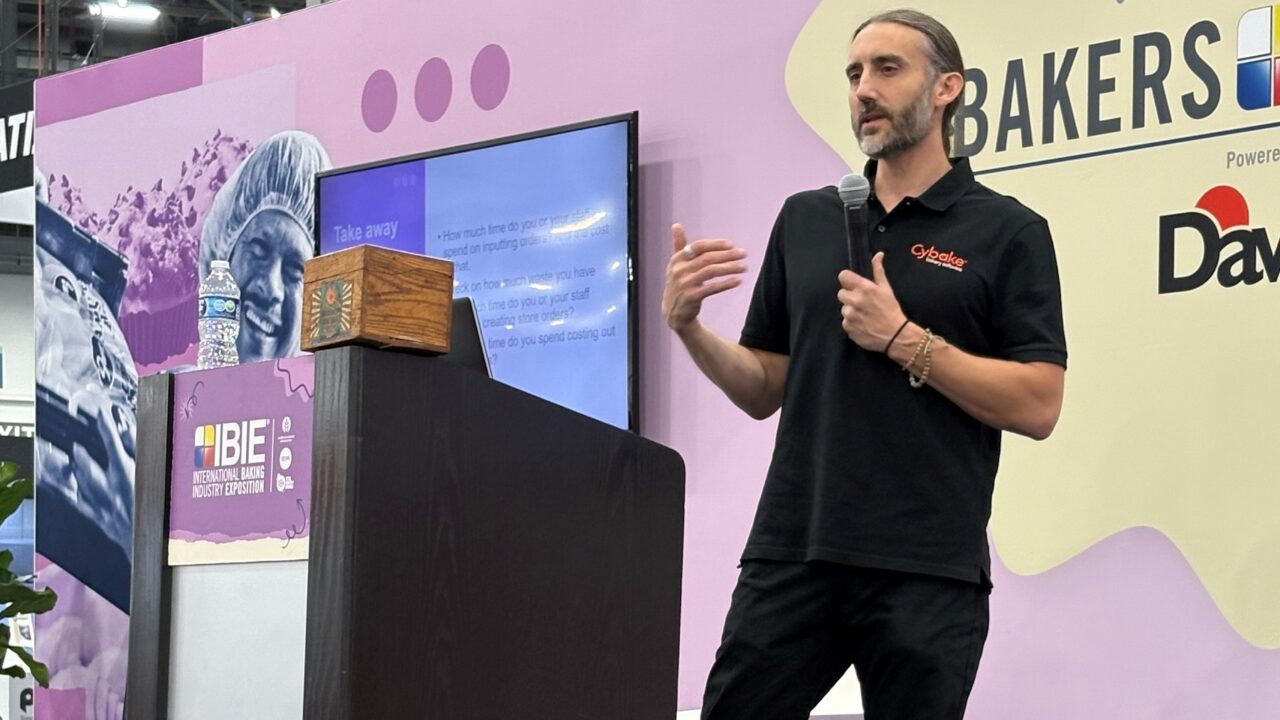 Photo of Cybake bakery software's Luke Karl on stage presenting at IBIE 2025 in Las Vegas