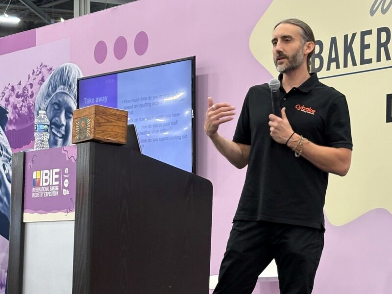 Photo of Cybake bakery software's Luke Karl on stage presenting at IBIE 2025 in Las Vegas