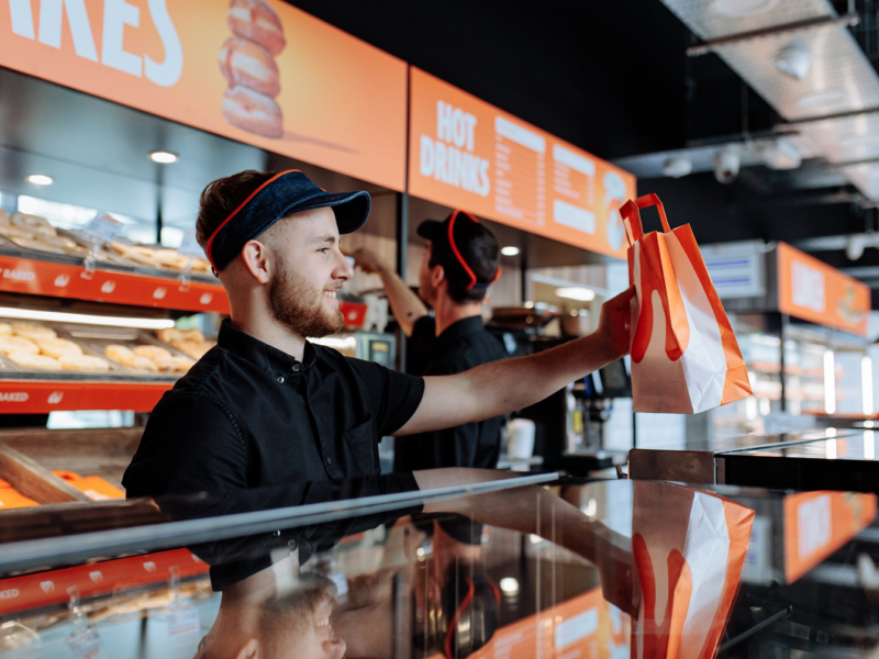 Photo of staff serving at the counter of a Wenzel's the Bakers retail store.