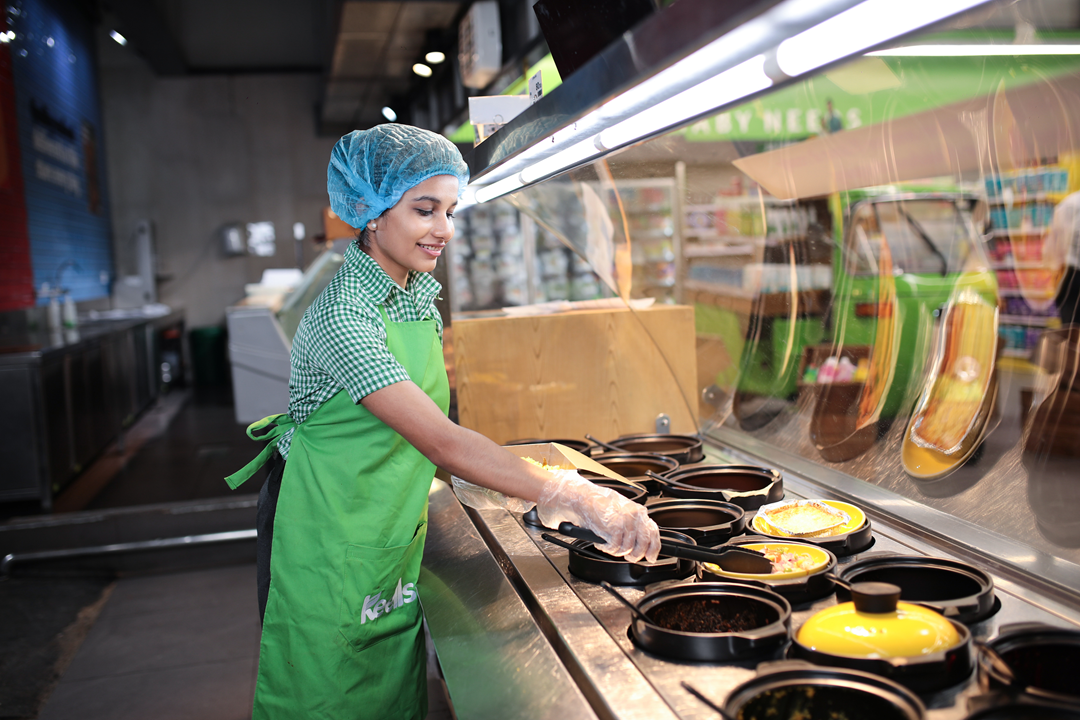 Photo of a store colleague at a Keells supermarket preparing food